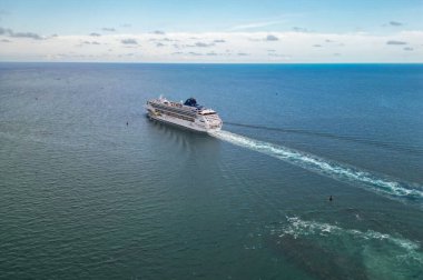 Miami, Florida, ABD - 7 Haziran 2024: Norveç yolcu gemisi. Gemi seyahati. Tatildeki yolcu gemisinin havadan görünüşü. Denizde seyahat et. Lüks yolcu gemisi. Gemi port 'tan ayrılıyor.