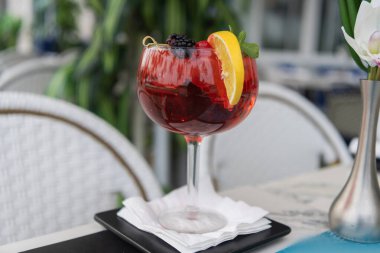 Sangria içiyor. Bir bardak sangria aperatif içeceği. Yaz içeceği. Barda kokteyl. Aperol sprey kokteyli. Sangria sürahi içeceği. Barda Aperatif. Yaz tazeleyici kokteyl.