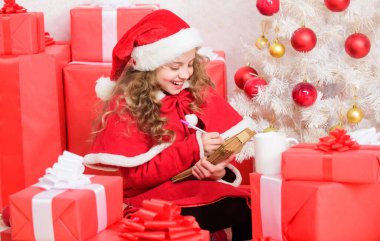Çocuk Noel Baba 'ya mektup yazmış. Sevgili Noel Baba. Mucizeye inan. Noel Baba 'ya mektup gönder. Dilek listesi. Çocuk Noel Baba kostümü afiyet olsun. Noel ağacı ve hediye kutusunun yanında kağıt kalem tutan bir kız..
