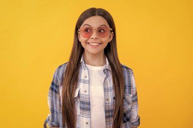 Kareli gömlek giyen mutlu bir genç kız. Uzun saçlı genç kız. Gündelik tarzda genç bir kız. Güneş gözlüklü genç kız. Moda düşkünü gençler..