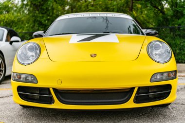 Chicago, Illinois - 29 Eylül 2024: Porsche 911 Carrera S sarı rengi. Porsche 911 Carrera S sokağa park etmiş. ön görünüm