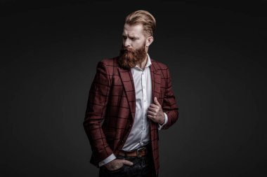Bespoke takımı. Özel dikim erkek giysisi giymiş sakallı adam. Özel dikim kıyafet giyen bir iş adamı. Şık takım elbiseli bir iş adamı. Resmi terzilik kıyafeti. Erkek giyim kuşamı. Bohem stili.
