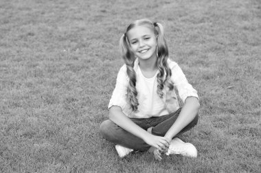 Gençliğin çocukluk tarzı. Yaz çimlerinde rahatla. Kız çimlerin üzerinde huzur içinde dinleniyor. Genç kızın mutlu çocukluğu. Yaz tatilinde parkta dinlenmek. Genç kız dışarıda oturuyor. özgürlük ve neşe.