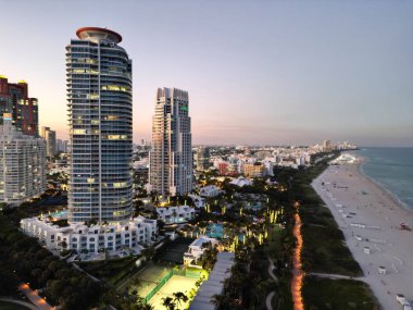 Miami South beach at night. Aerial view on skyscraper cityscape at night. Night city aerial view. Luxury skyscraper in Miami, Florida. City skyline in evening sunset. Aerial waterfront cityscape. clipart