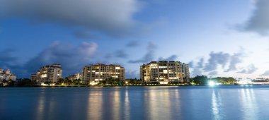 Night aerial view of Fisher island, Miami. Miami beach with waterfront architecture. Miami residential building. Fisher island. Travel destination. Fisher island night view. Illuminated building. clipart