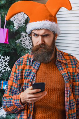 Telefonlu Xmas adamı. Noel selamı. Mutlu noeller. Mutlu Geceler. Telefon bağlantısı aktif. Xmas bayramı kutlaması. Yılbaşı arifesinde Noel Baba. Aralık tatili Şapkalı adamı selamlıyor.