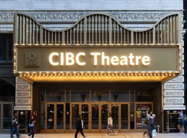 Chicago, Illinois, ABD - 22 Ekim 2024: CIBC Tiyatrosu. Şehir merkezinde sanat eserleri sergileyen CIBC tiyatro ışığı girişi. Chicago 'daki CIBC Tiyatrosu manzarası. Chicago caddesinde yürüyen insanlar.