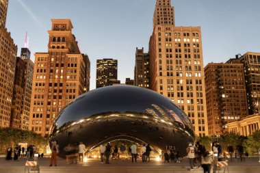 Chicago, Illinois, ABD - 22 Ekim 2024: Millennium Park ve popüler Cloud Gate heykeli. Fasulye heykeli. Gökdelenli gece şehri manzarası. Chicago Milenyum Şehir Parkı. Bulut Kapısı.