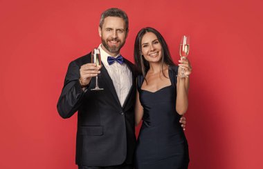 Sevgililer Günü. Yıldönümünü kutlayalım. Aşık çift nişanı kutluyor. Zarif çift kırmızıda izole edilmiş şampanya içer. Resmi olarak bir çift. Romantik randevu kutlamaları.