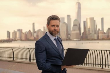 İnternette çalışan bir iş adamı. İş adamı dışarıda bilgisayar ya da dizüstü bilgisayarda çalışmakla meşgul. Adam internet tarayıcısından iş e-postası ve sörf yolluyor. New York 'ta serbest çalışan bir iş adamı. Değer oluştur.