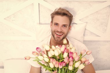 Kadınlar günü çiçekleri olan pozitif bir adam. Kadınlar günü çiçekleri olan romantik bir adam. Kadınlar günü çiçekleri olan bir erkek. Kadınlar Günü çiçekli bir erkeğin fotoğrafı..