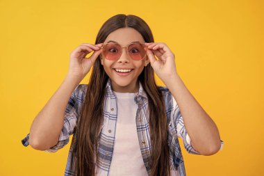 Gündelik tarzda genç bir kız. Güneş gözlüklü genç kız. Kareli gömlek giyen güzel bir genç kız. Uzun saçlı genç kız. Yaz modası.