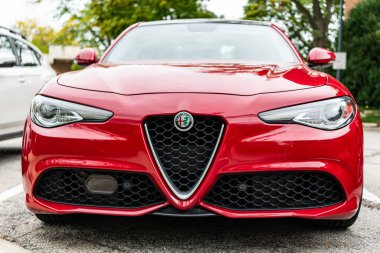 Chicago, Illinois - 29 Eylül 2024: 2017 Alfa Romeo Giulia kırmızı renk. 2017 Alfa Romeo Giulia sokağa park etmiş. 2017 Alfa Romeo Giulia ünlü İtalyan spor arabasıdır. ön görünüm