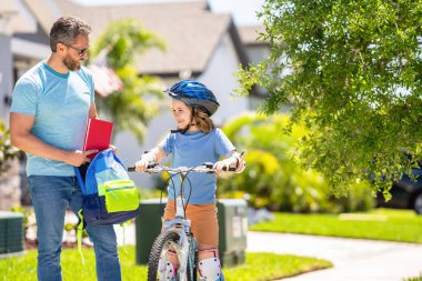 Baba oğluna ilk bisiklet sürüşünde rehberlik ediyor. Pedal çeviren ortaklar. Baba oğul bisiklet gezintisinin keyfini çıkarıyorlar. Baba ve oğul bisiklet macerasında. Baba ve oğul pedal çeviriyor resimli manzarada.
