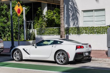 Miami Beach, Florida USA - 9 Haziran 2024 Miami plajında Porsche Taycan beyaz rengi. Ocean 'daki lüks araba porshche' si Miami plajına gidiyor. ön köşe görünümü