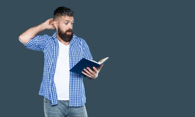 amazed bearded man reading book on grey background. clipart