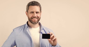 happy man with business debit in studio. man holding business debit. photo of man hold business debit. man show business debit isolated on studio background.