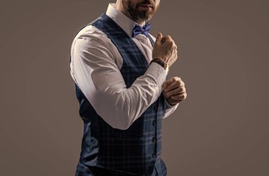 Gri arka planda beyaz takım elbiseli adam izole edilmiş. Stüdyoda smokin giyen adam. Smokinci adam resmi kıyafet giyer. Takım elbiseli şık smokinli papyonlu adam..