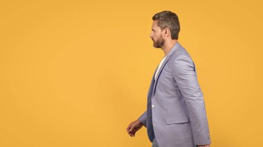 Yakışıklı CEO 'nun resmi. Takım elbise giyip yürüyün. CEO resmi bir ceket giyiyor. Beyaz ceketli CEO sarı arka planda izole edilmiş. Stüdyoda genel müdür..
