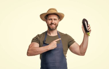 Önlüklü, şapkalı, patlıcan sebzeli, beyaz tenli bir adam. işaret parmağı.