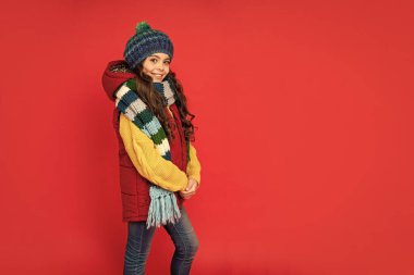 Kadın manken. Eşarplı genç kız. Kalın giysiler giyen çocuk. Olumlu duygularını ifade et. Kış modası. kopyalama alanı. Şapkalı, kıvırcık saçlı mutlu çocuk..