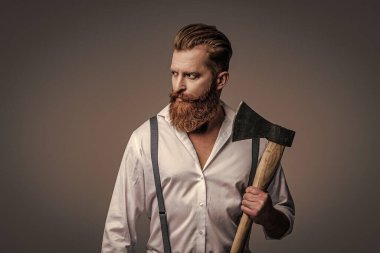 Antika pantolon askılı, eski tip bir gaddar adam. Askılık giymiş vahşi bir adam gride izole edilmiş. Saçları kızıl saçlı, olgun bir adam. Acımasız erkek modası. Erkek vahşeti. Aşırı vahşilik..