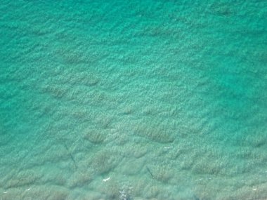 Deniz suyu yüzeyi. Okyanusun dalgalı suyu. Aquamarine okyanus doğası. Temiz turkuaz deniz suyunun arka planı. Idyllic yaz tatili. Karayip Denizi. Hava görüntüsü. Dalgalı yüzey.