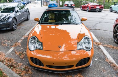 Chicago, Illinois - 29 Eylül 2024: Porsche 911 Turbo Carrera S turuncu rengi. Porsche 911 turbo Carrera S üstü açılabilir parkı yolda..