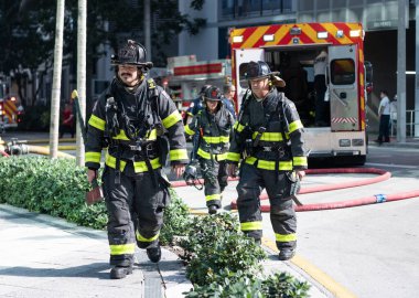 Miami, Florida, ABD - 01 Aralık 2024: itfaiye ekibi kurtarma görevinde hortumdan su kullanıyordu. Miami İtfaiyecisi. 911 acil durum. Üniformalı itfaiyeci. İtfaiyeci takımı..