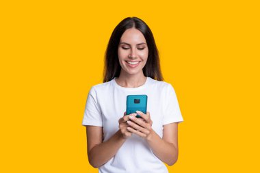 İletişim sohbeti. Kadın blogcu sarıda izole edilmiş akıllı telefon kullanıyor. İnternette ve blogda sörf yapmak. Sohbet ve mesajlaşma. Milenyum kadınları internette sohbet ediyor. Telefondaki kadın blogu. Aşk mesajı.