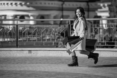 Genç kız alışveriş çantasıyla yürüyor. Sonbahar alışverişi. Genç kız sonbaharda alışveriş torbasını tutuyor. Sonbahar indirimi ve indirim. Şehirde genç bir kız. kopyalama alanı. Satın almadan hayran olmak.