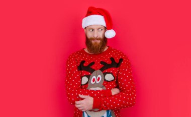 Noel Baba şapkalı utangaç yeni yıl adamı. Yeni yıl tatili. Yeni yılda sakallı Noel Baba Red 'de izole edilmiş..