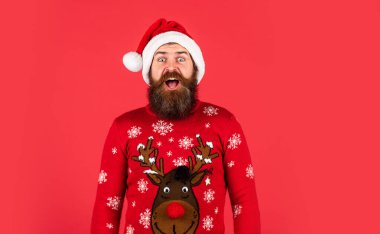 Noel Baba şapkalı adam Noel hediyesini bekliyor. Noel 'den önceki sabah. Hipster tatilin tadını çıkar. Yeni yıl alışverişi fikri. Parti kutlaması için hazırım. Kazaklı sakallı adam..