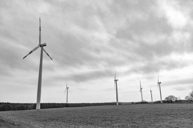 Kırsal kesimde bir yel değirmeni. Deniz aşırı rüzgar parkı. Rüzgar Türbinleri Çiftliği. Alternatif yenilenebilir enerji üretimi. Yeşil enerji kavramı. Yenilenebilir elektrik üretimi için rüzgar değirmeni.