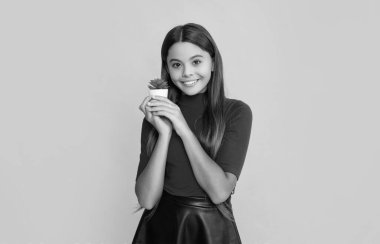 Sarı arka planda kaktüs içinde gülümseyen çocuk..