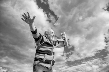 Gökyüzü geçmişinde yaşlı yaşlı bir adam. Emeklilikteki son sınıf. Dışarıda oyuncak uçağı olan yaşlı emekli bir adam..