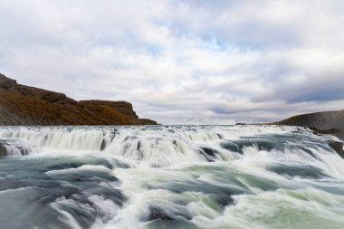 Şelale nehri taşkını. İzlanda doğası nehir akıntısı. Resimli Gullfoss şelalesi deresi. Doğa vahşiliği. Nehir taşması. Şelale deresi akıyor. Gullfoss şelalesi doğası. Kristal çağlama.