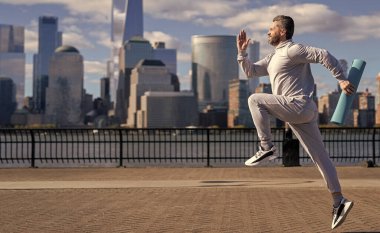 New York 'ta sabah sporu koşucusu. Spor antrenmanında koşan koşucu. Sporcu koşucu ya da koşucu. Spor takım elbiseli bir adam koşu yapıyor. Manhattan 'da koşan adam. Boşluğu kopyala.