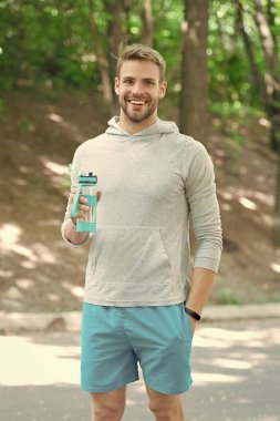 Sportsman man in activewear keep healthy lifestyle by drinking water and do sport or fitness workout outdoor. clipart