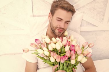 Erkeklerin kadın kokusu alan çiçek buketinin fotoğrafı. Kadınlar günü çiçekleri olan bir adam. Kadınlar günü çiçekleri olan romantik bir adam. Kadınlar günü çiçekli erkek sping 'de.