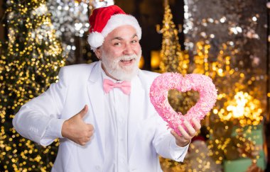 Real feelings. senior santa in tuxedo on christmas lights background. garland new year decor. gift with love. happy businessman decorative heart. he loves xmas holidays. this winter may be joyful. clipart