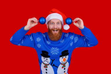 - Mutlu yıllar. Xmas bayramı kutlaması. Yeni yılda Noel Baba. Noel Baba şapkalı adam için kış tatili. Xmas kazağı. Madalyası olan adam kırmızıda izole edilmiş. Mutlu noeller. Şenlikli dekorasyonlar.