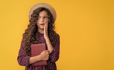 amazed kid with frizz hair hold book on yellow background. clipart