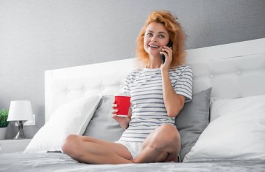 Kahveli mutlu kadın telefonla arıyor. Evdeki kadının telefonu var. Kadının evine telefon var..