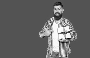 Gri arka planda tatil kutusu olan olgun sakallı adam..