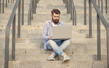 Serbest Çalışan Adam 'ın dışarıda online bilgisayarı var. Serbest çalışan bir adamın sokakta bilgisayar bağlantısı var. Dizüstü bilgisayarı olan serbest çalışan bir adam. Serbest Çalışan Adam 'ın online bilgisayar iletişimi var.