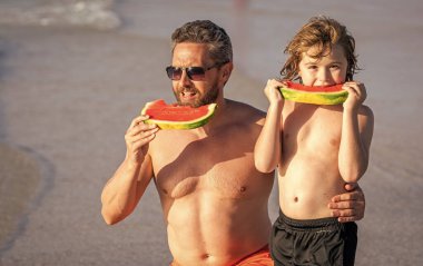 Baba ve oğul denizde ebeveynliğin tadını çıkarıyorlar. Aile bağları ve değerleri. Baba ve oğul karpuz yiyor. Baba ve oğul yazın ebeveynlik yapıyor. Yalnız bir baba ve oğlu sahilde..