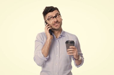 İş adamı iletişim için telefonu kullanıyor. Kahveli bir iş adamı beyazın üstüne izole edilmiş. Kahve molası. İş iletişimi. Adam iş konuşuyor. Telefon var. İddialı iletişim.