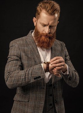 Dakik adam siyah üzerine izole edilmiş zamanı kontrol ediyor. İş için son gün. İş hayatına geç kalan bir iş adamı. Zaman yönetimi. Dakik adam, nöbete geç kalma zamanını kontrol ediyor. Kol saati aksesuarı.