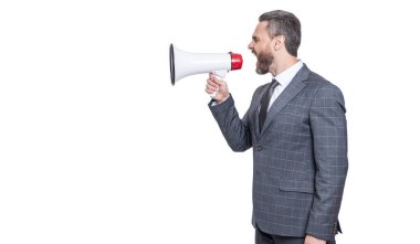 Hoparlördeki çalışana bağıran bir işadamı beyaz ışıkta izole edilmiş. İş adamının terfi konusunda ortağıyla anlaşmazlığı var. İş adamı rekabeti duyurdu. İş çatışması. Boşluğu kopyala.